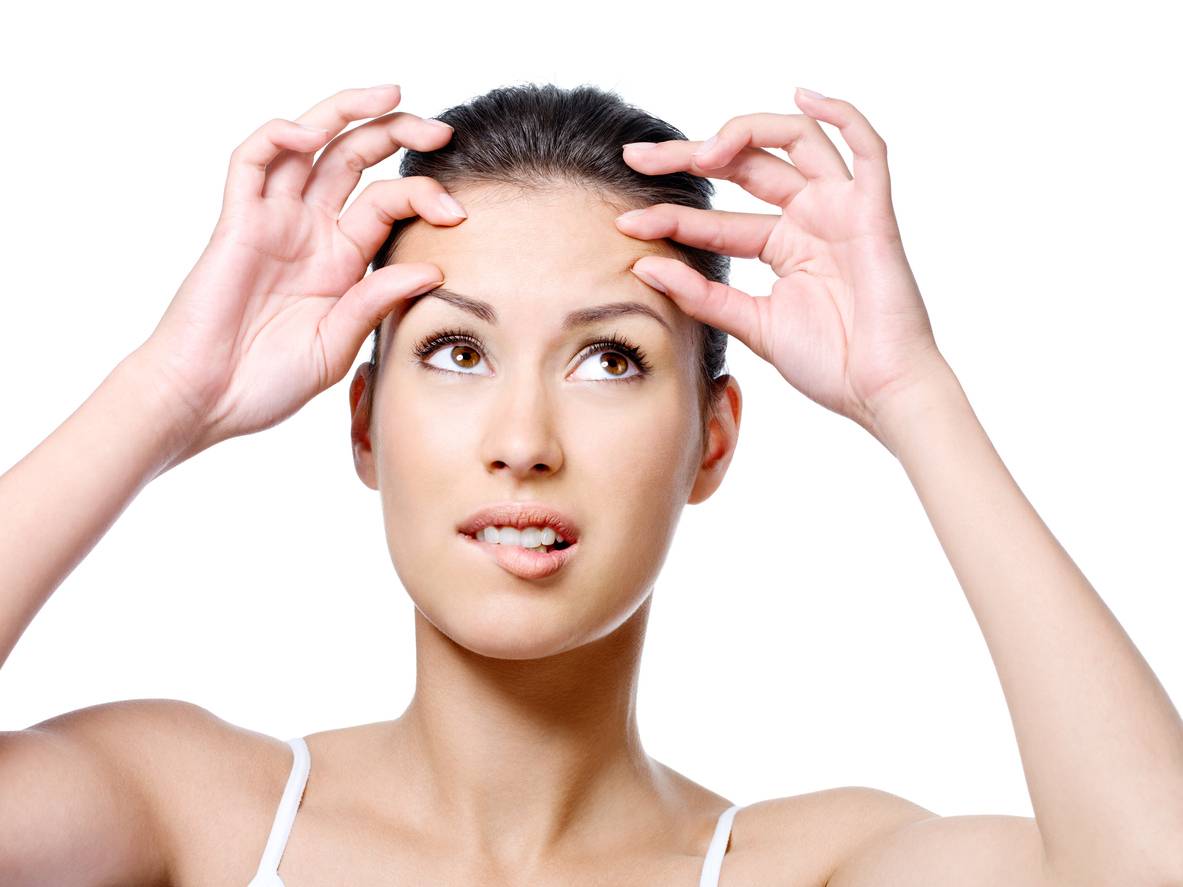 Stock image or woman pinching her forehead skin